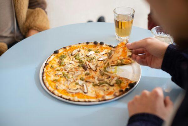 Mouth-watering mushroom pizza served with a drink, captured in a cozy indoor setting.